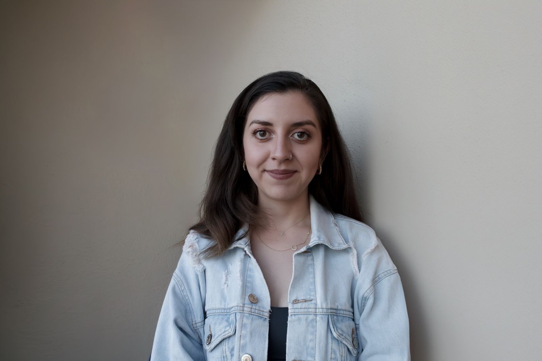 Retrato de la autora sonriendo en estudio con fondo neutro